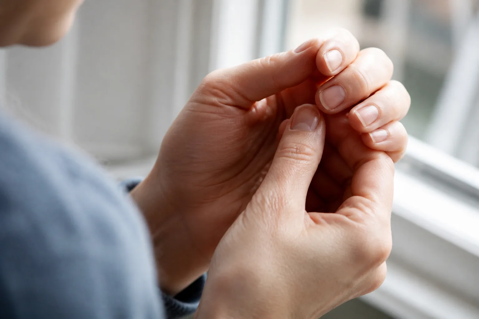 Detail rukou při kontrole nehtů, které mohou doprovázet psoriázu